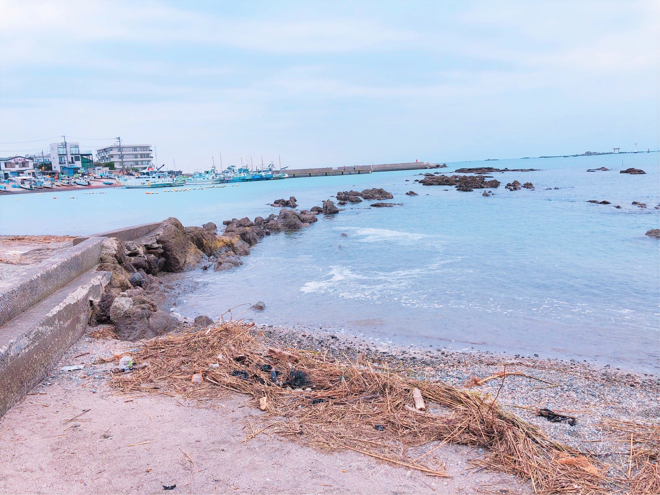 真名瀬海岸。街並みと海の色、ごつごつした石が多い砂浜の対比が素敵。