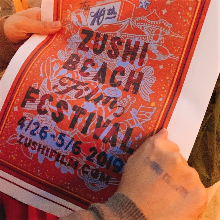 逗子海岸映画祭2019のパンフレット。手には入場の証であるスタンプを押してもらう。遊園地に入るみたいで、わくわく感が増す瞬間だ。