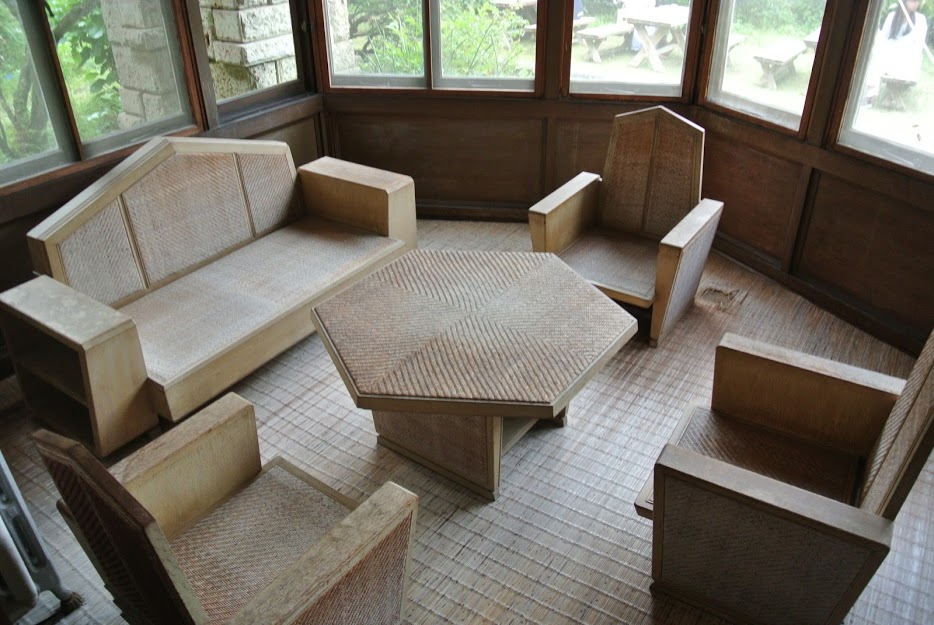 加地邸の家具。六角形のテーブルと、半六角形の背もたれのイスが並ぶ。