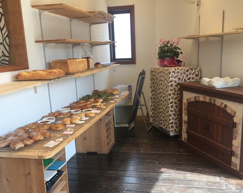 アップルの店内。写真左には長い木のテーブルに、パンがずらりと並んでいる。写真右には窯が見える。