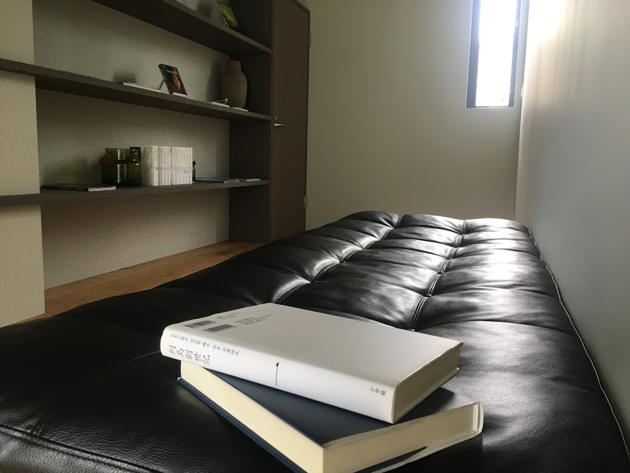 雲海のヴィラ2階にはライブラリースペースがあり、本棚にはオーナーが選書した本が並び、手前の黒い皮のソファでゆったり読書を楽しめる。