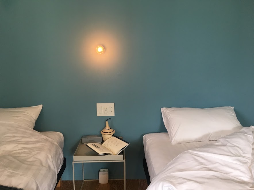 シングルベッドが2台並ぶベッドルーム。枕元の壁はターコイズブルーでオシャレ。