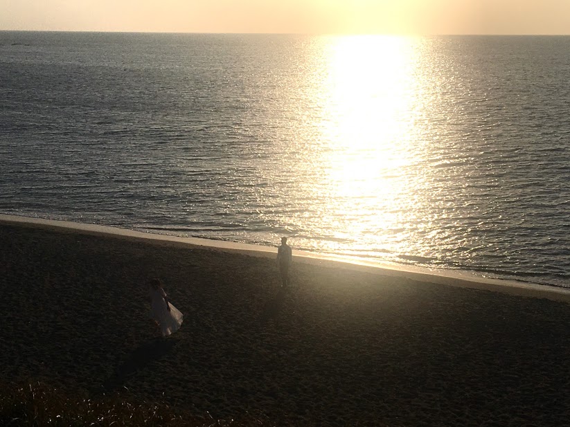 大浜海岸の夜明け。朝焼けの浜にカップルの影が見える