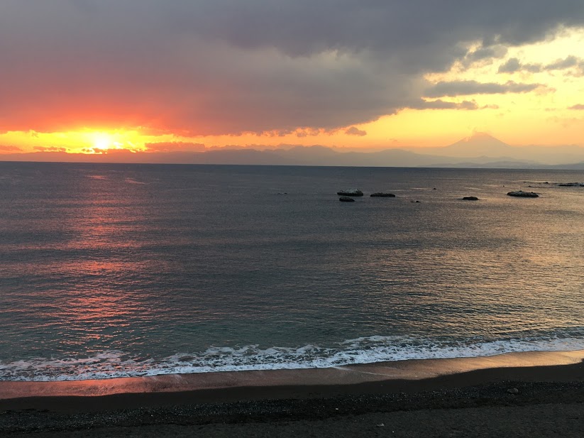 大浜海岸の夕景。地平線の左側には紅く輝くサンセット、右側には富士山のシルエットが見える